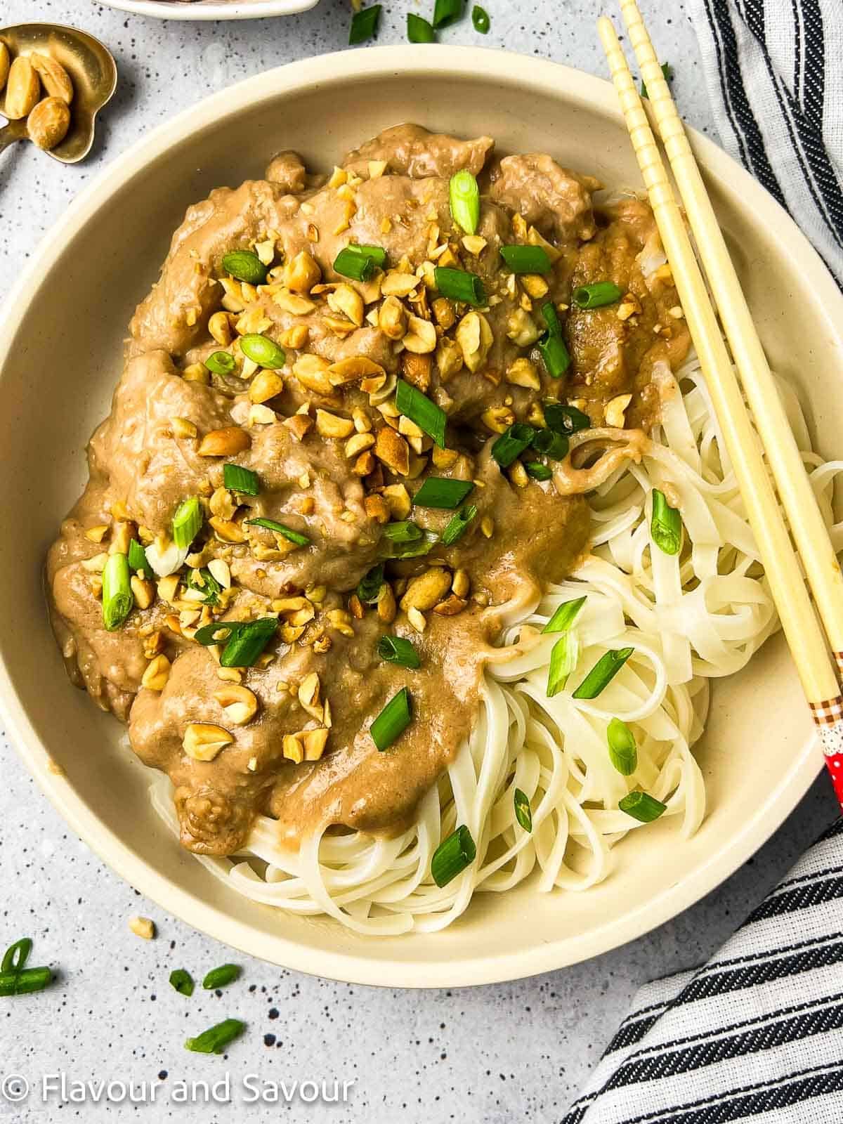Thai peanut chicken with pad Thai noodles, chopped peanuts and green onions.
