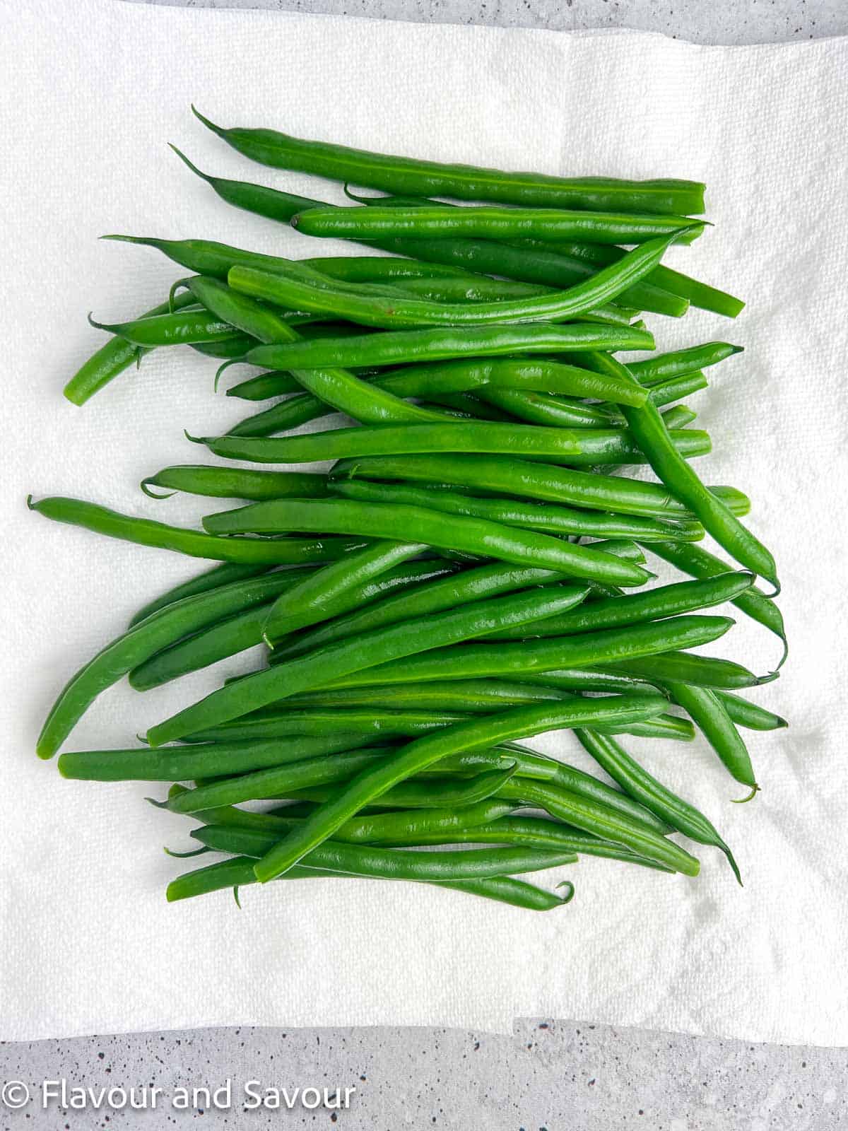 Blanched green beans on a piece of paper towel.