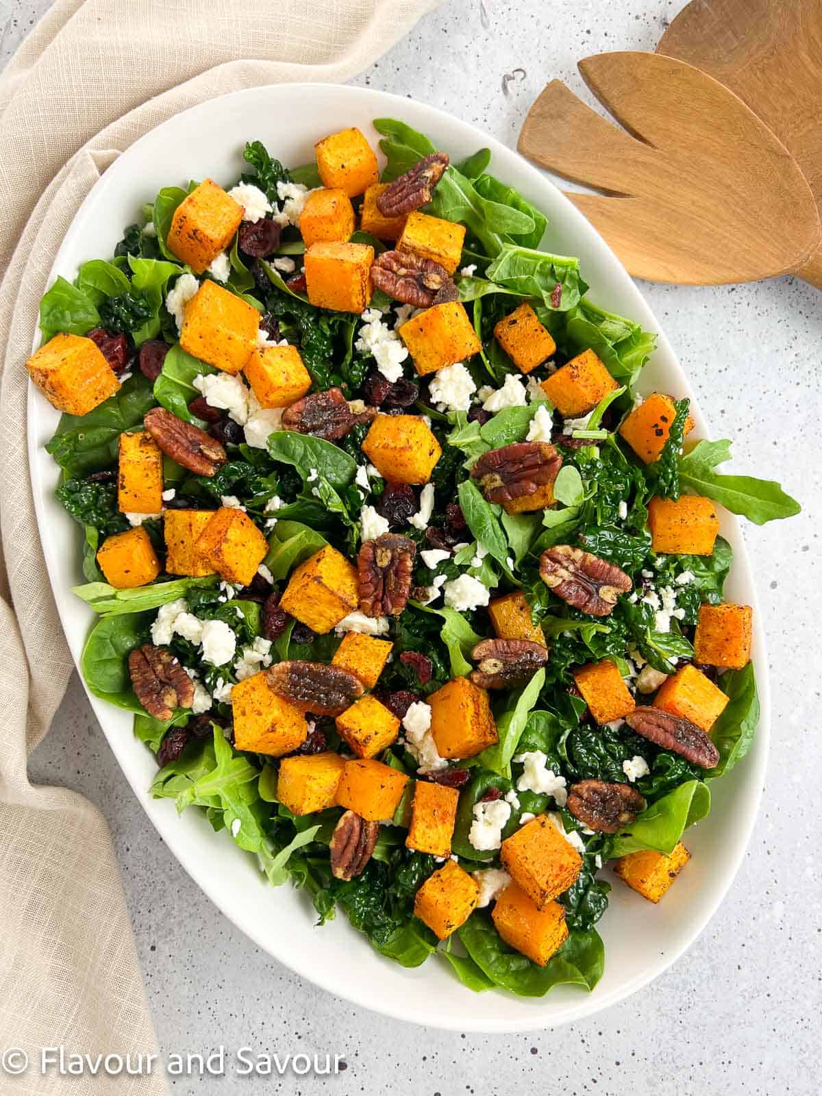 Butternut squash salad with cranberries, toasted pecans, and feta cheese on a bed of mixed greens.