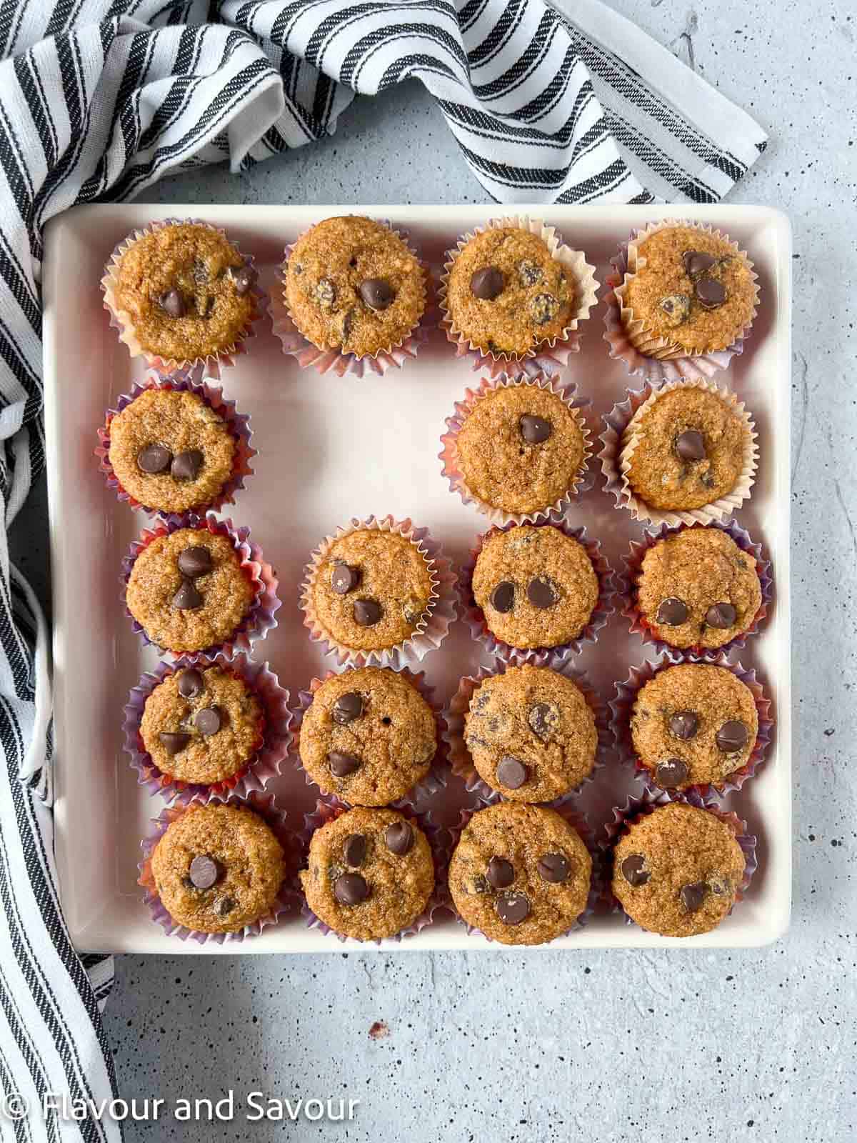 Mini gluten-free dairy-free chocolate chip pumpkin muffins on a white serving dish.