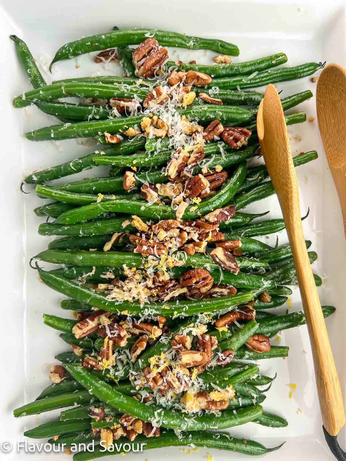 Sauteed garlic parmesan green beans with pecans on a serving dish.
