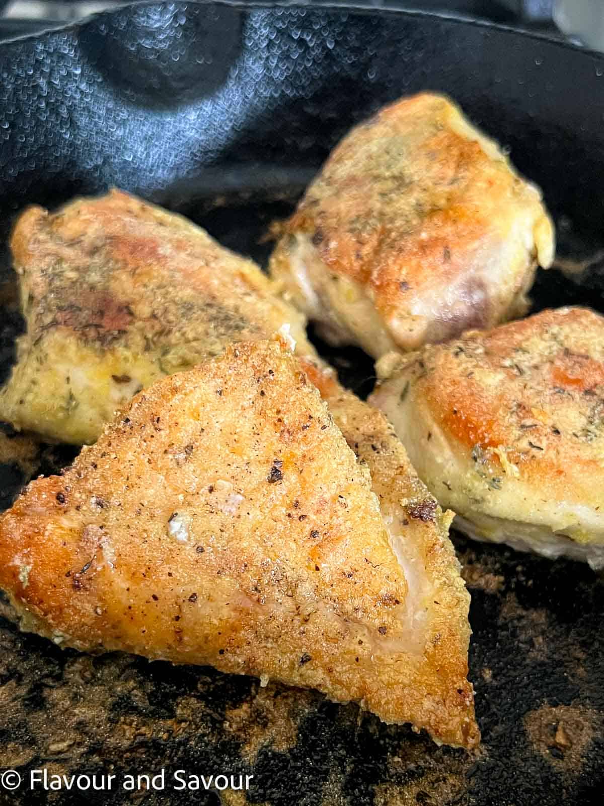 Browned chicken breasts in a cast iron skillet.