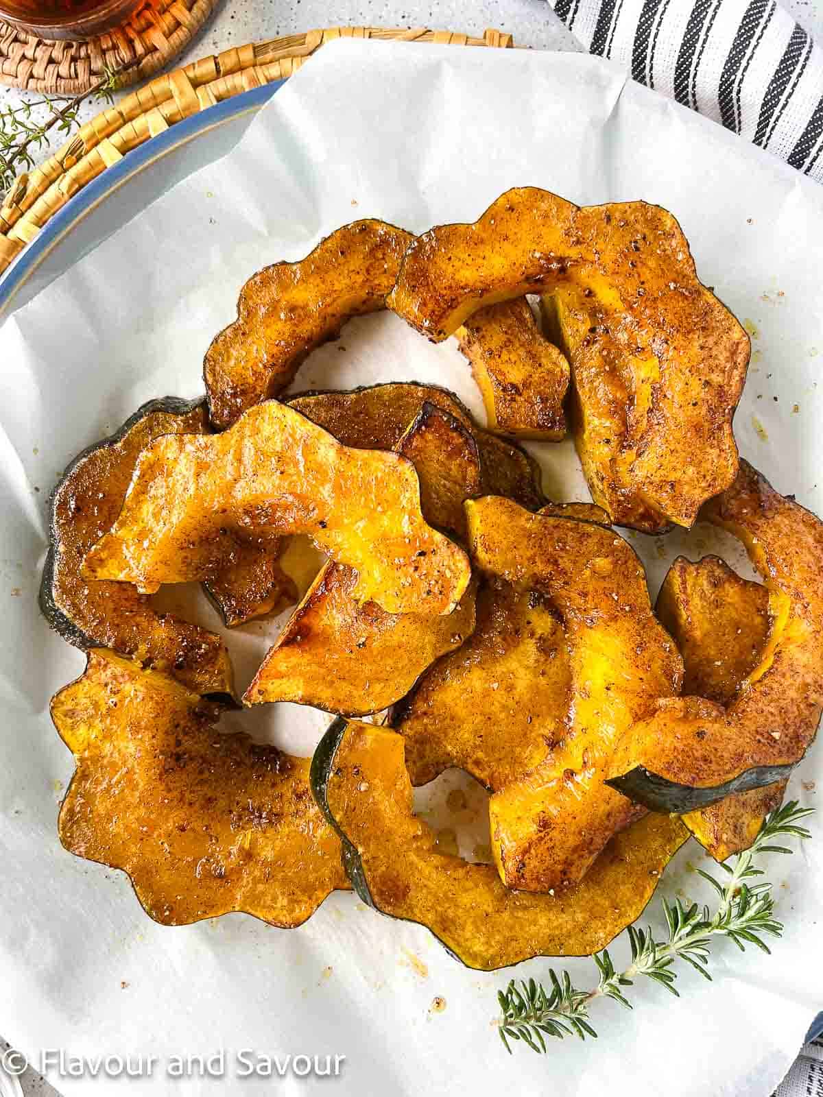 Acorn squash slices with maple syrup, cinnamon and sea salt on a platter.