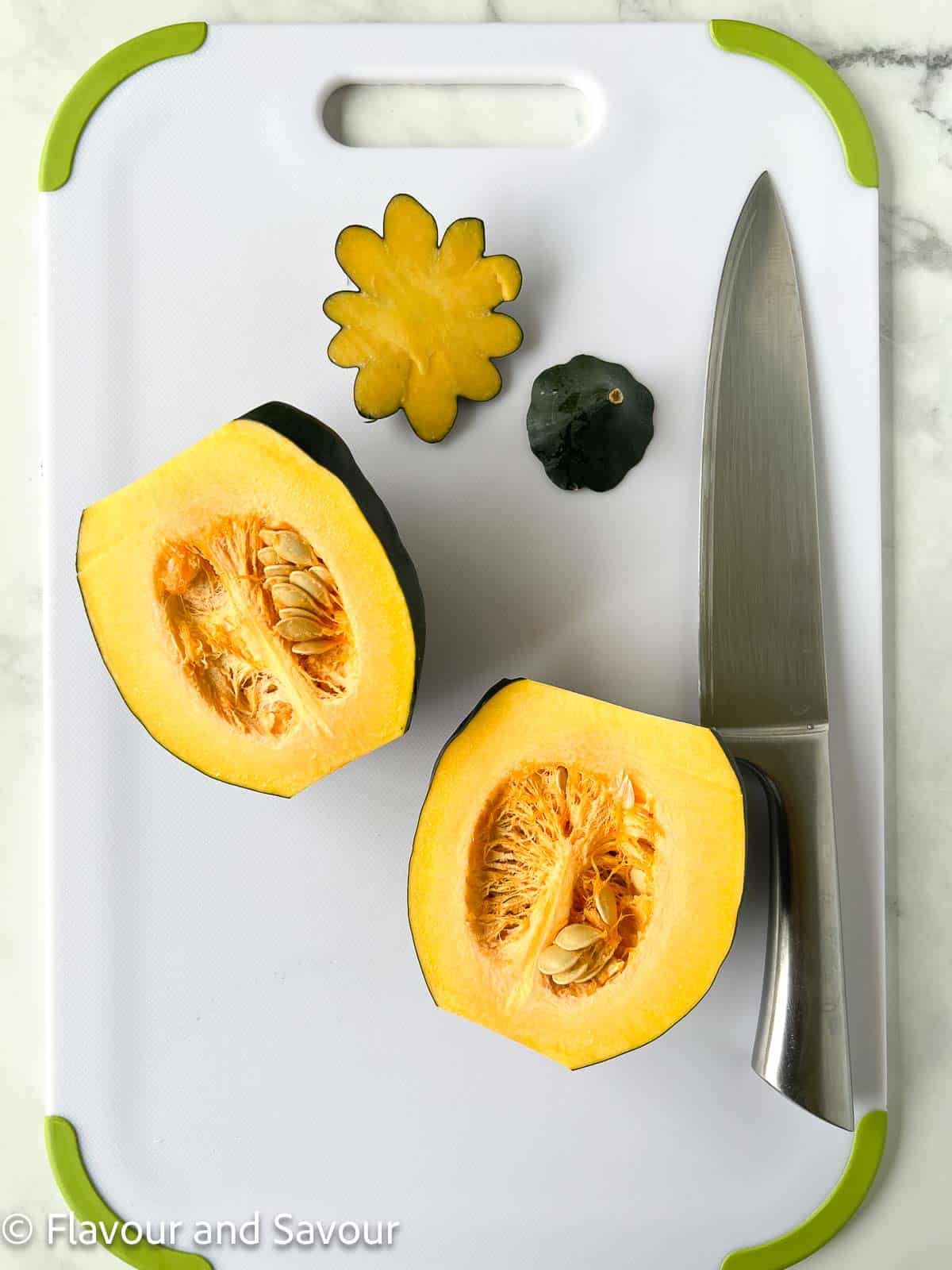 An acorn squash cut in half showing the seeds and membranes inside.