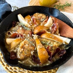Square image of one-pan chicken with prosciutto, pears and parmesan cheese in a cast iron skillet.
