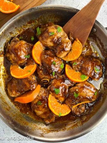 Hoisin orange chicken thighs in a skillet.