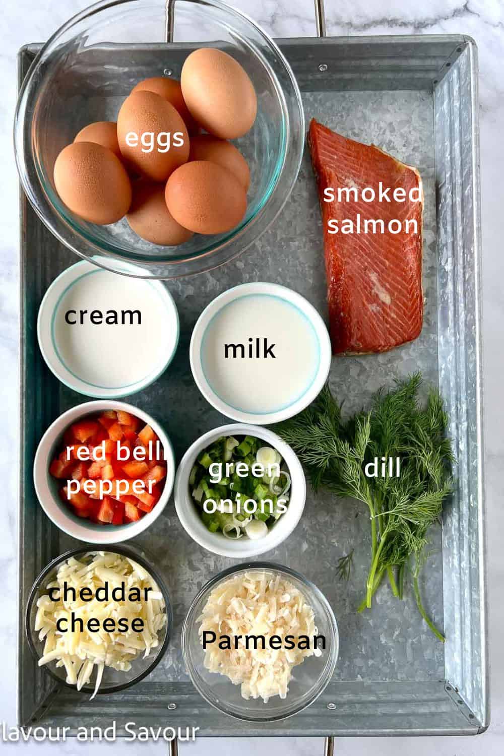 Ingredients to make mini crustless smoked salmon quiches: eggs, cream, milk, smoked salmon, cheddar cheese, parmesan cheese, fresh dill, red bell pepper, green onion, olive oil, salt and pepper.