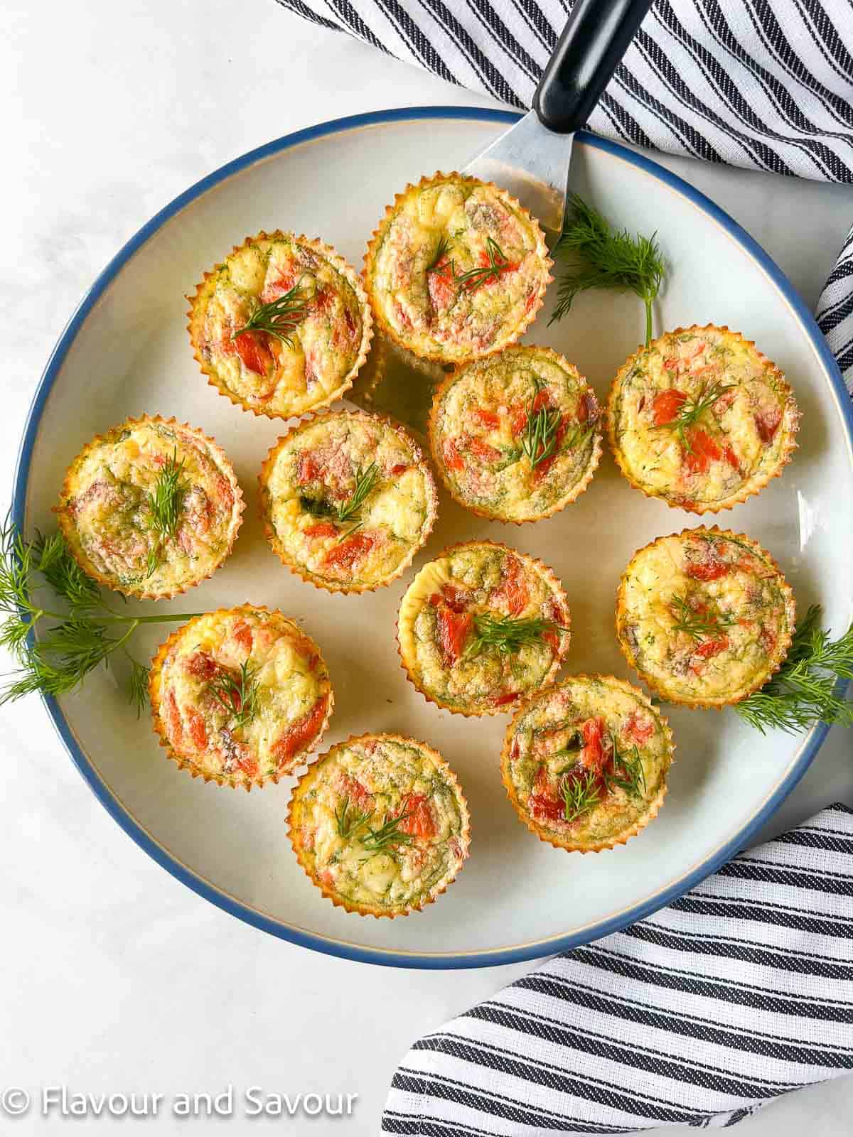 Mini crustless smoked salmon quiche arranged on a plate with a small serving lifter.
