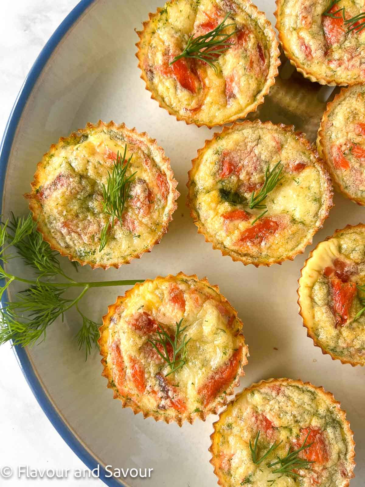 Individual tiny quiche with smoked salmon and dill.