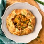 Potato galette with bacon and cheese made with almond flour pastry on a plate, garnished with chives.