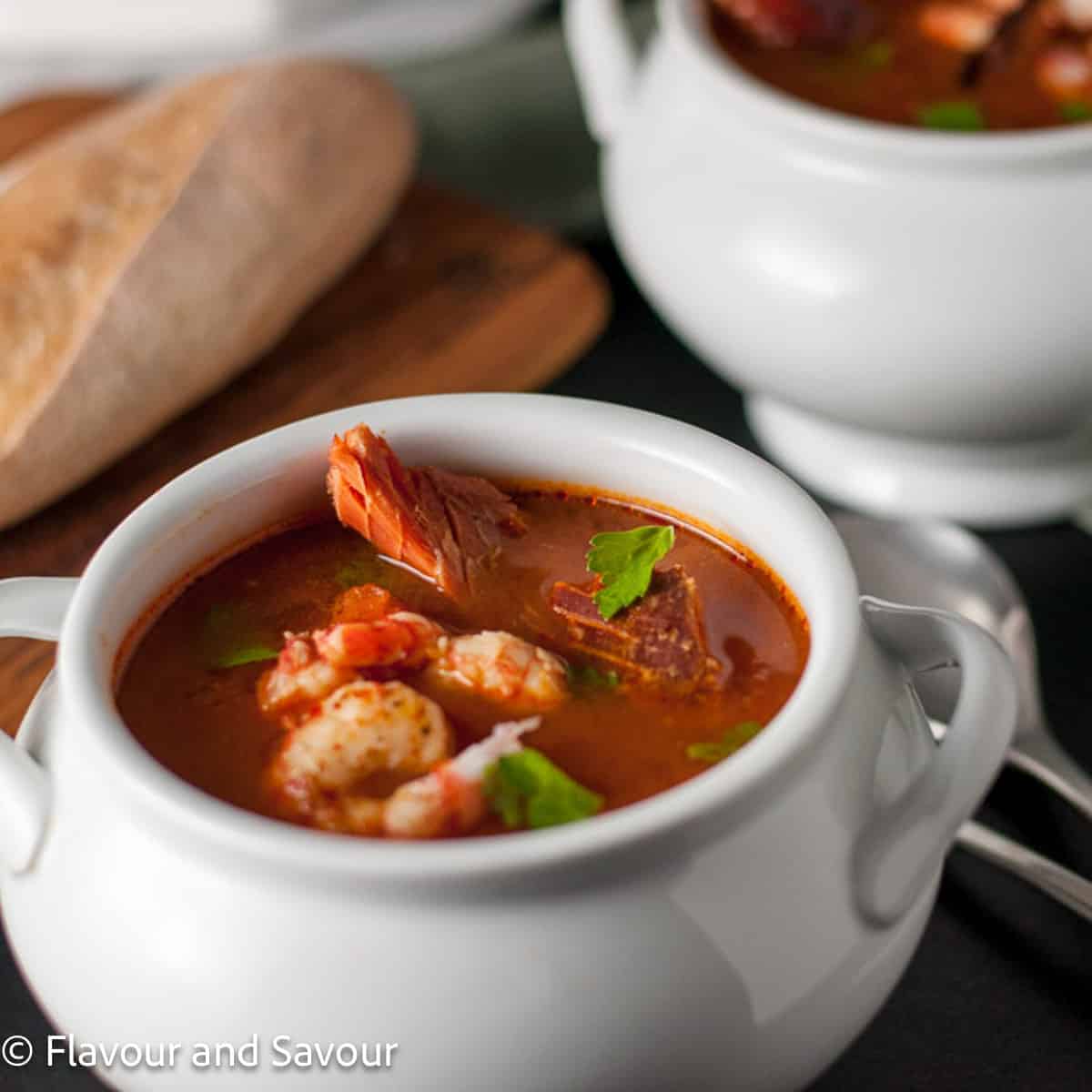 A bowl of cioppino with salmon, shrimp, white fish, scallops and more.