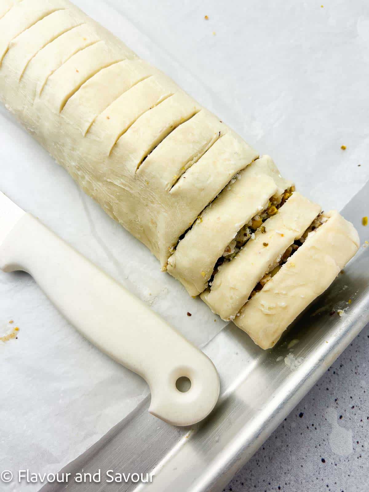 A sliced log of puff pastry pinwheels before baking.