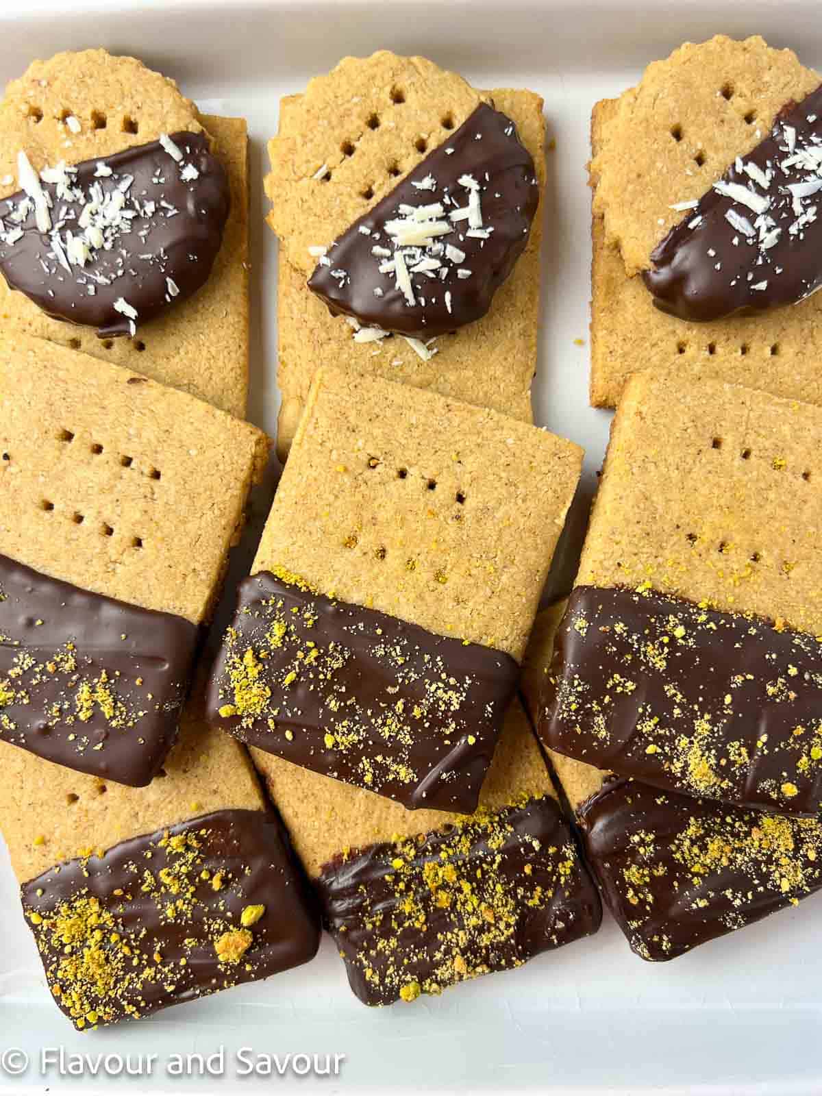 Espresso almond flour shortbread cookies dipped in chocolate and garnished with either crushed pistachios or shaved white chocolate.