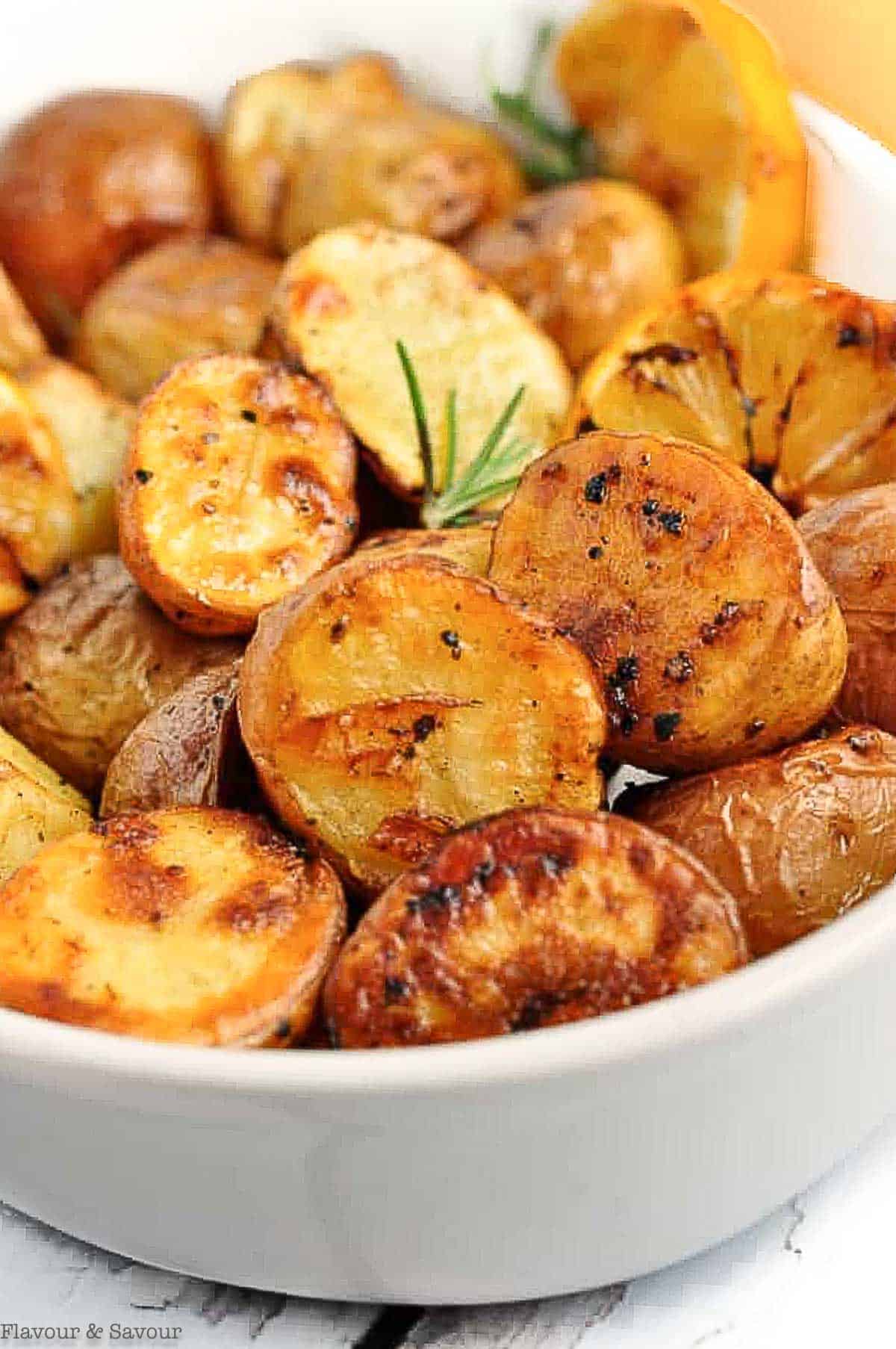 Close up view of a bowl of oven-roasted potatoes with lemon.