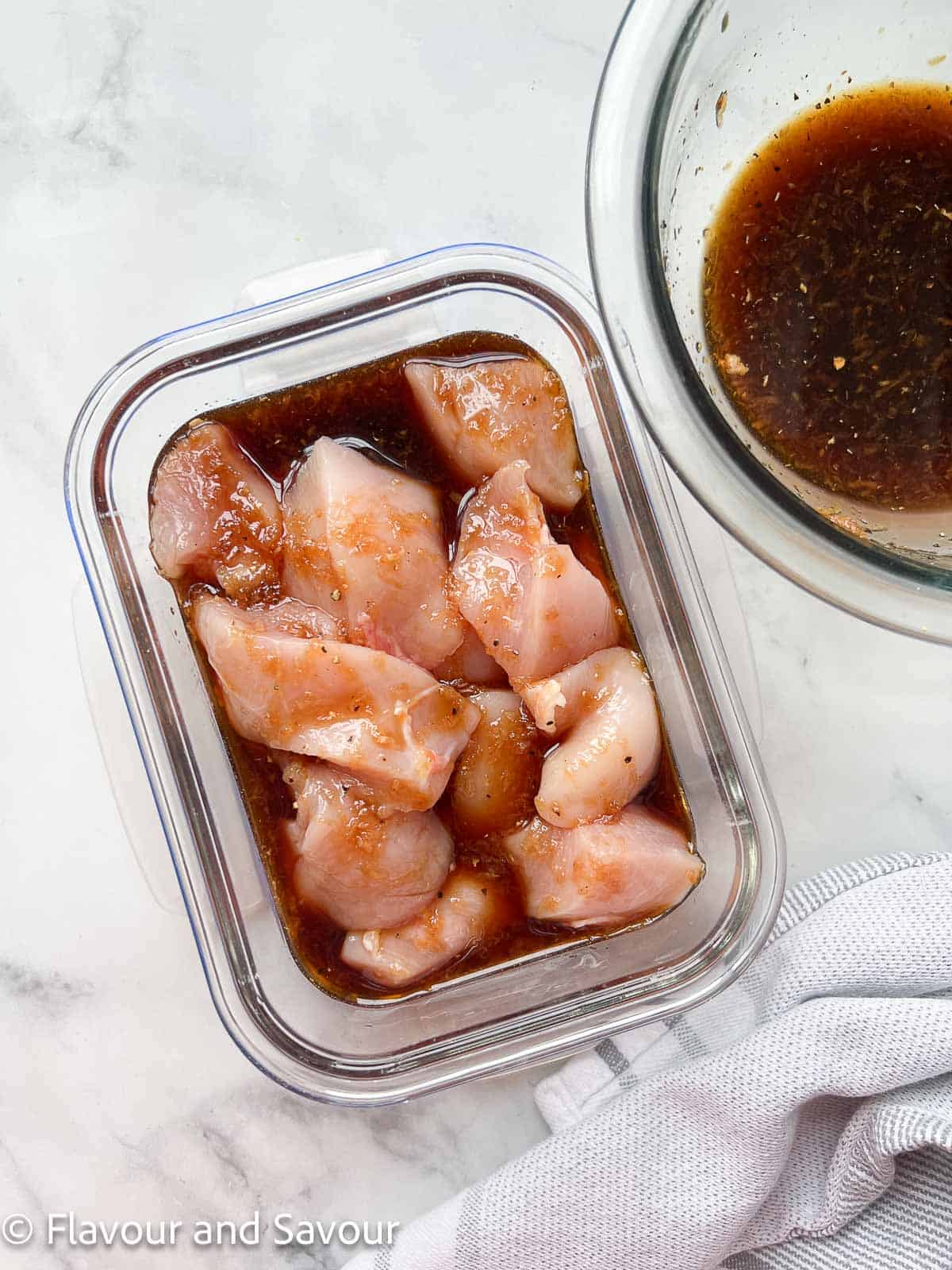 Maple garlic chicken cubes in a glass storage container.