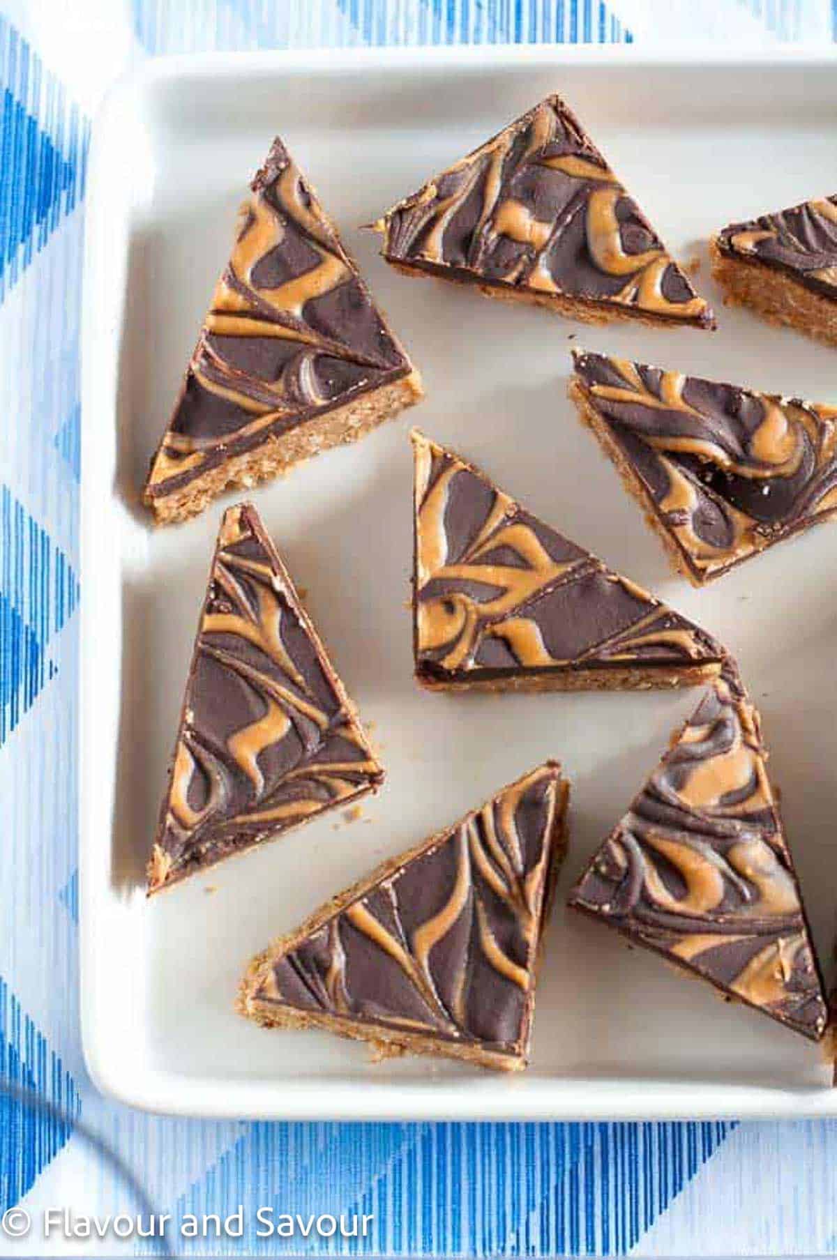 Peanut butter bars with a swirled chocolate topping cut into triangles.