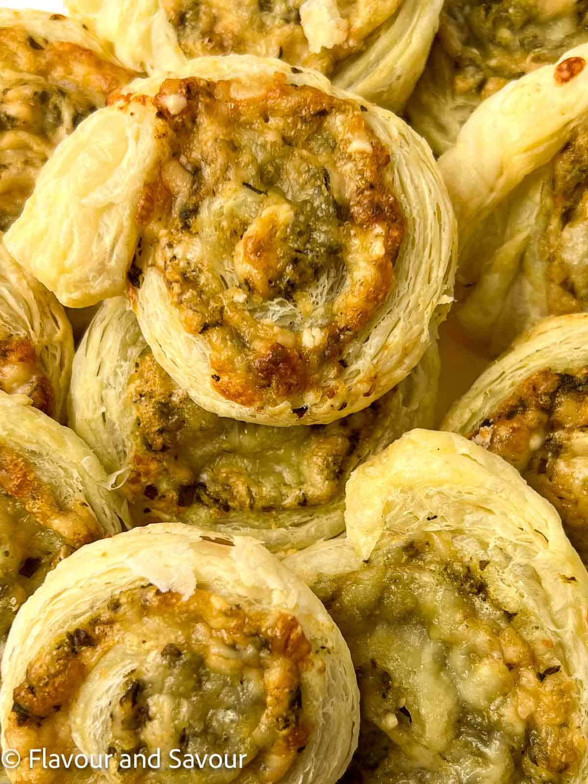 Pinwheel appetizers made with puff pastry, pesto and cheese.