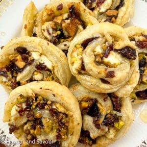 Cranberry Pistachio Puff Pastry PInwheels overlapping on a plate.