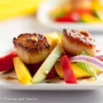 Two seared scallops with freshly sliced mango.