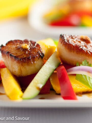 Two seared scallops with freshly sliced mango.