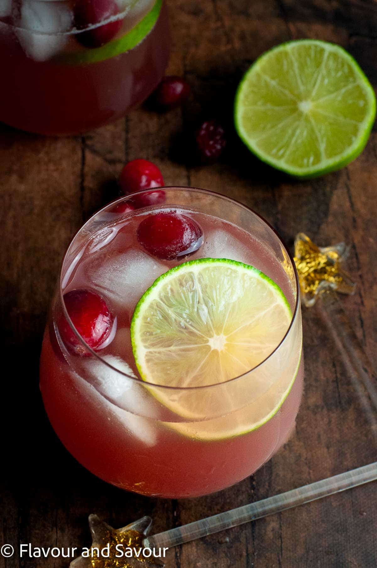 A glass of cranberry pineapple Christmas punch with a slice of lime.