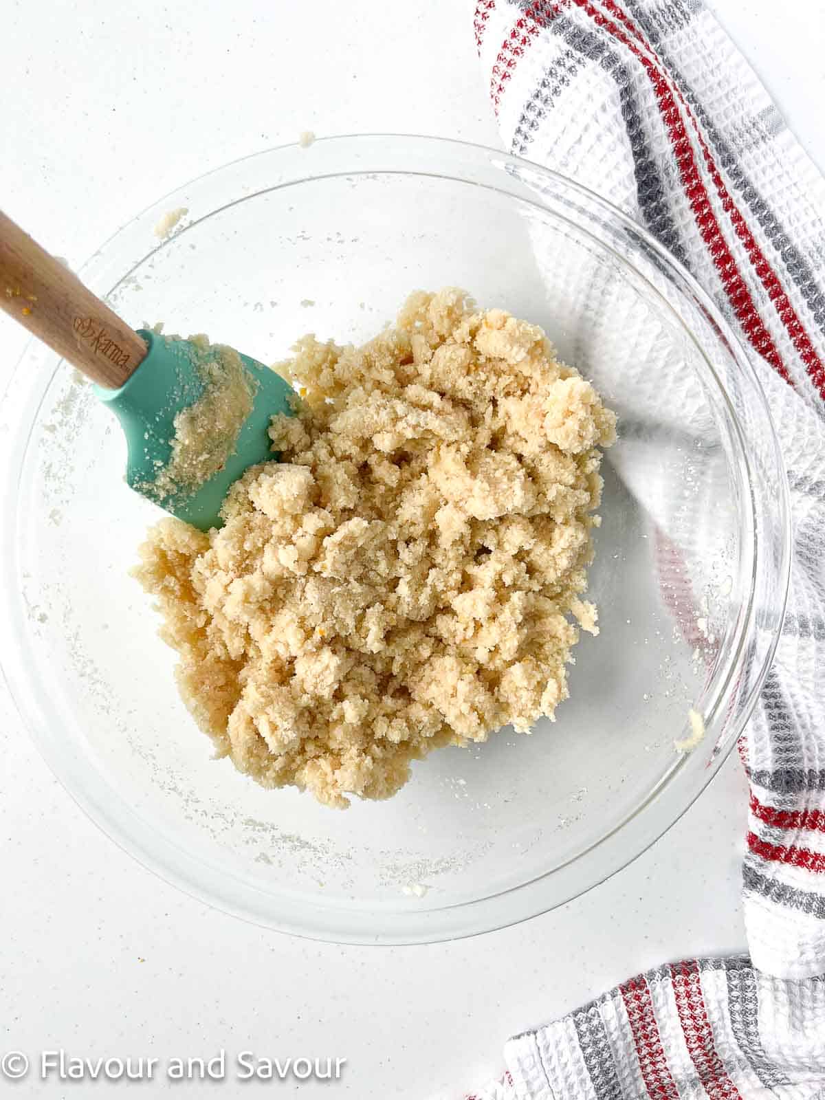 Amaretti cookie dough in a bowl with a spatula.