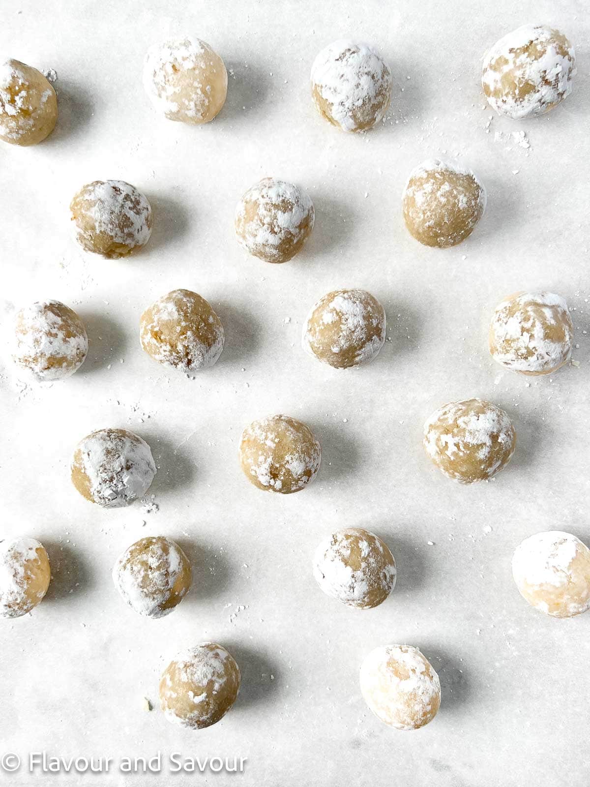 Almond cookie dough balls on a baking sheet, ready to bake.
