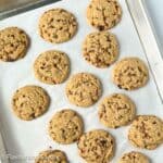 Toffee chocolate chip cookies on a baking sheet.