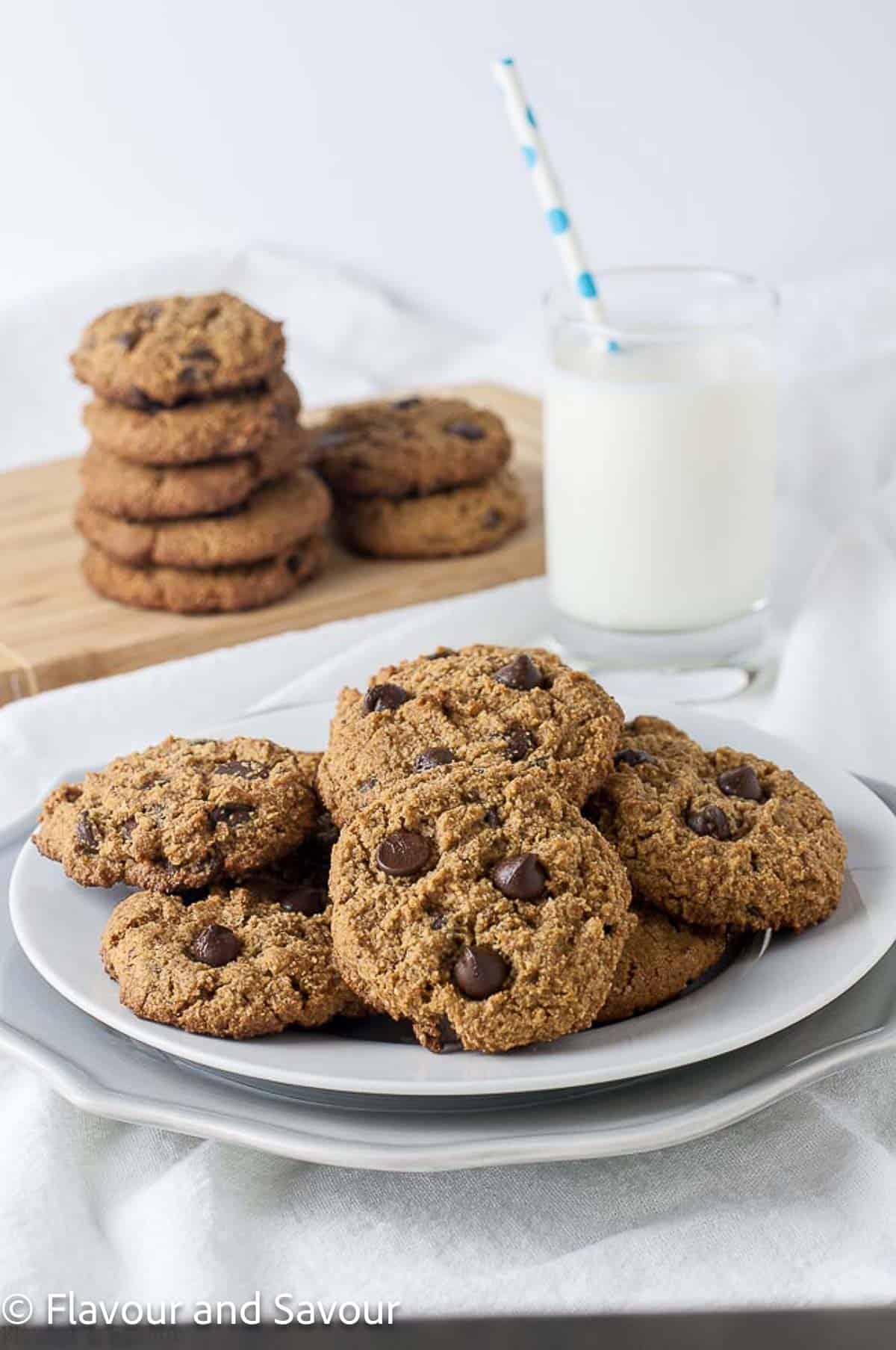 Chocolate chip cookies on a plate with a glass of milk.