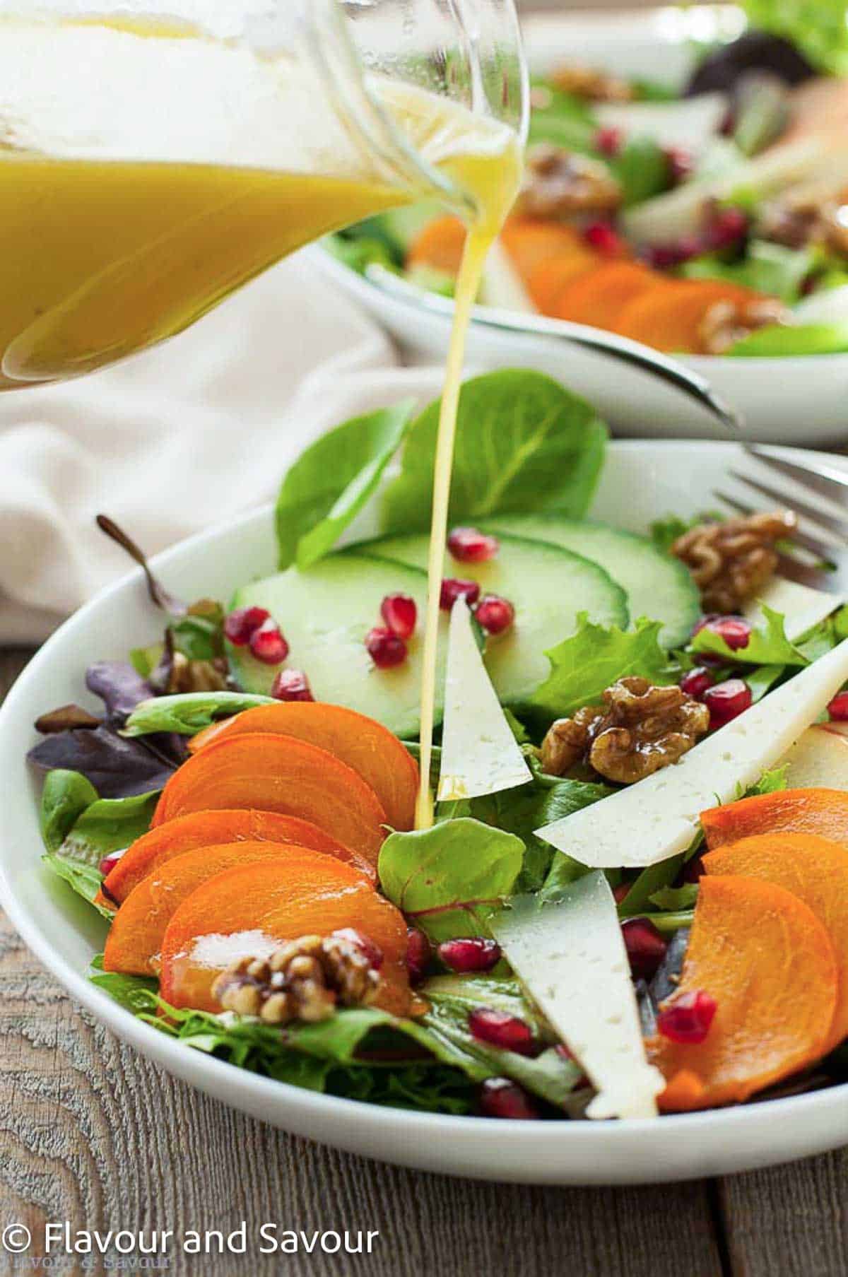 Pouring dressing on persimmon salad.