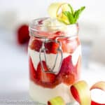 Strawberry rhubarb parfait layered with rhubarb compote and yogurt in a jar.