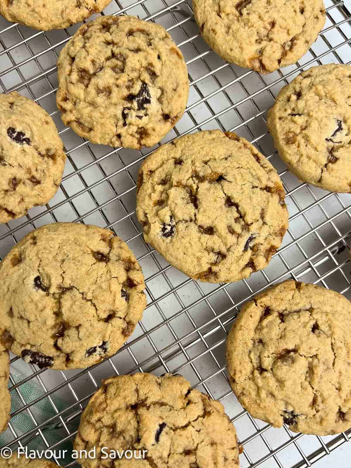 Gluten-free chocolate chip cookies with toffee bits on a wire cooling rack.