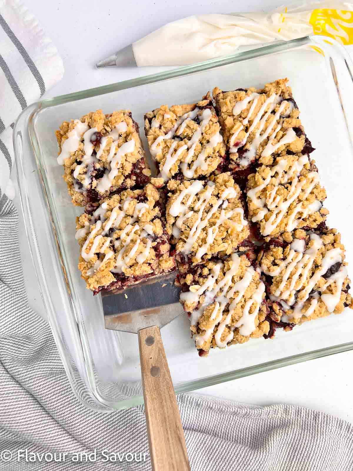 Cherry oatmeal crumble bars sliced in a glass baking dish.