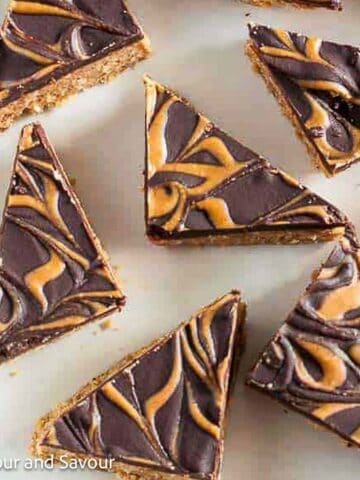 Peanut butter chocolate bars with swirled chocolate topping cut into triangles.
