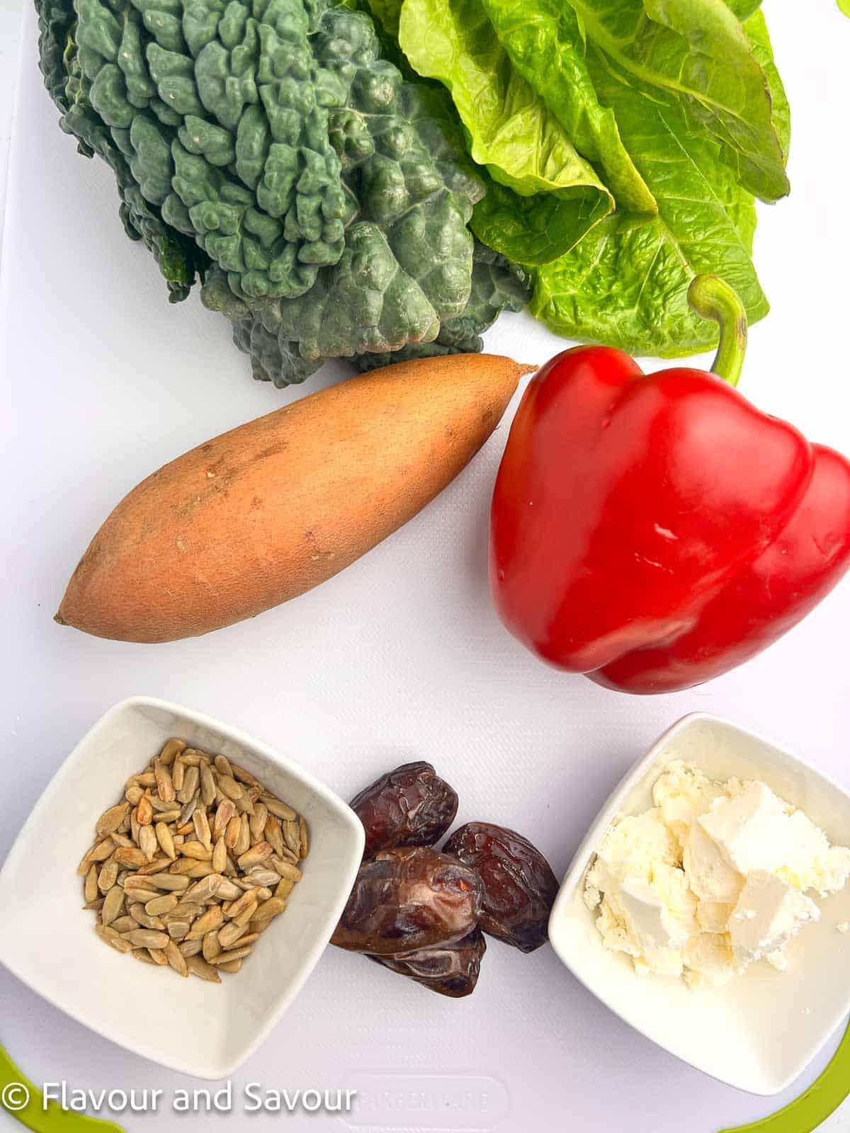 Ingredients for Roasted Sweet Potato Kale Salad: kale, romaine, red pepper, sweet potato, sunflower seeds, dates, and feta cheese.