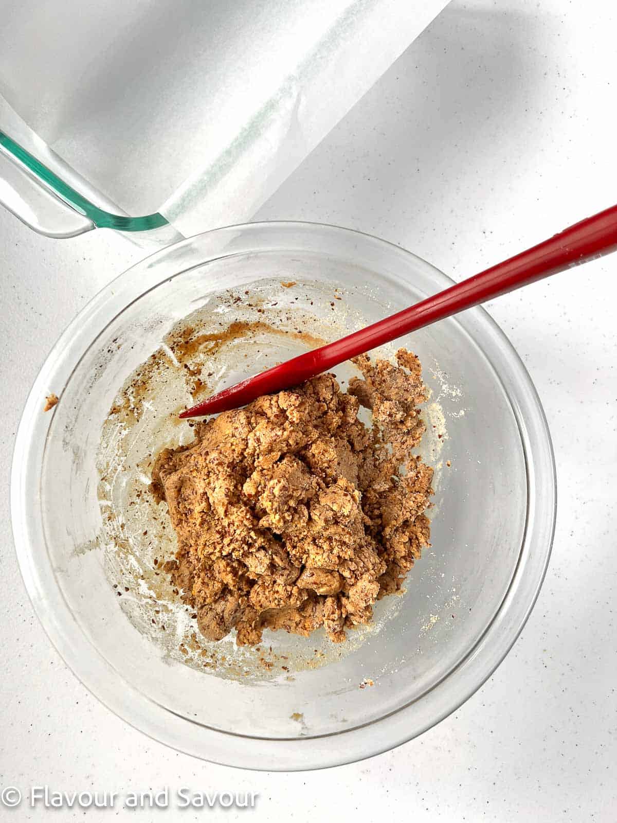 Peanut butter collagen batter in a glass bowl with a spatula.