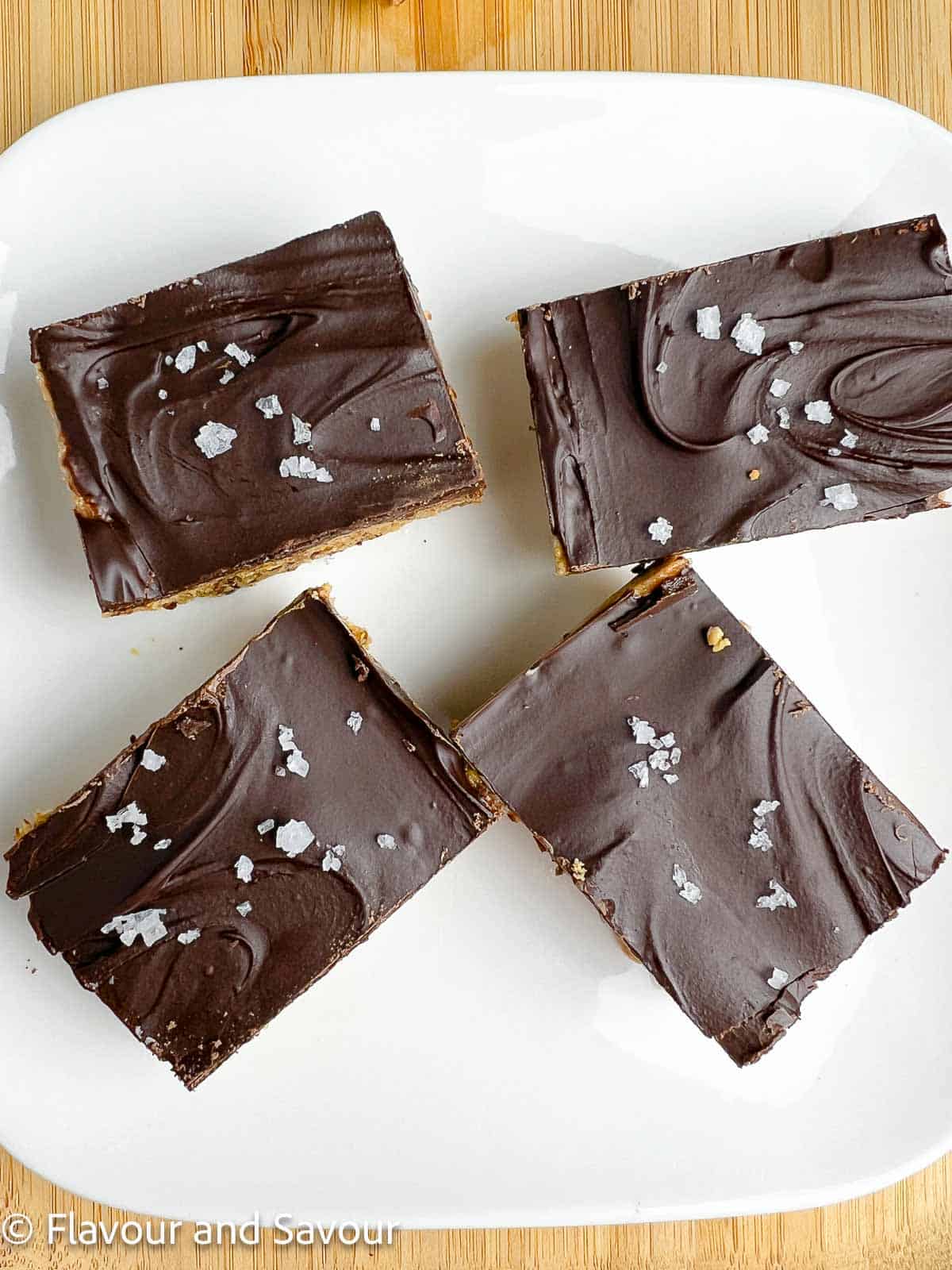 Peanut butter collagen bars topped with chocolate and flaky sea salt.