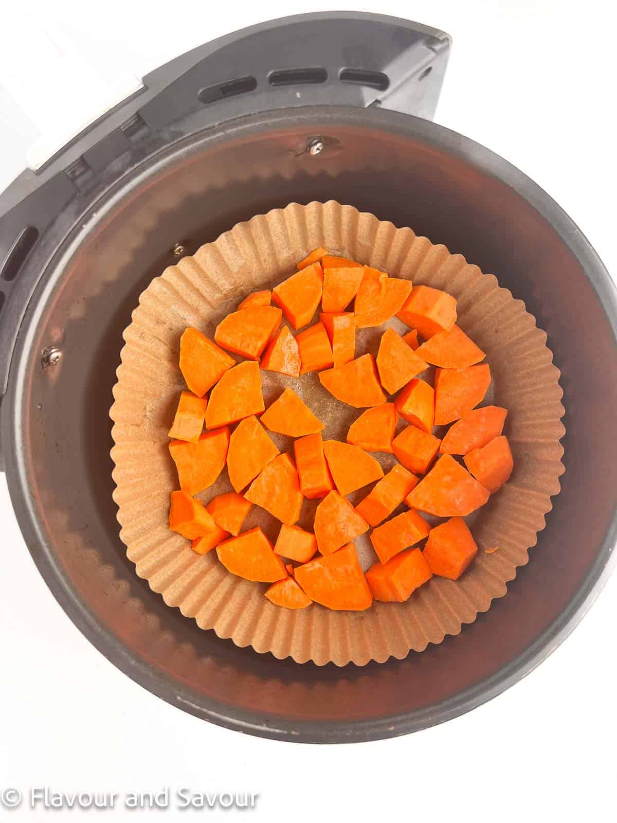 Chopped sweet potatoes in an air fryer basket.