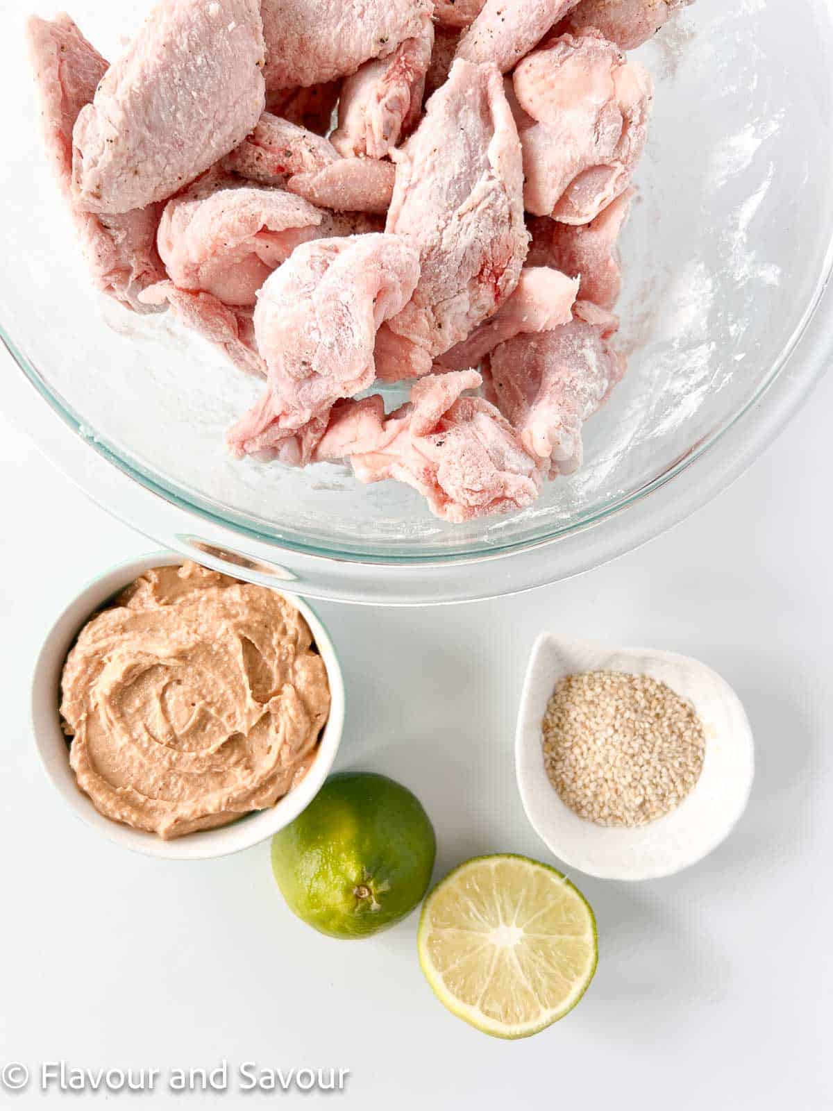 Ingredients for Air Fryer Thai Peanut Chicken Wings: wings, peanut sauce, sesame seeds, lime.