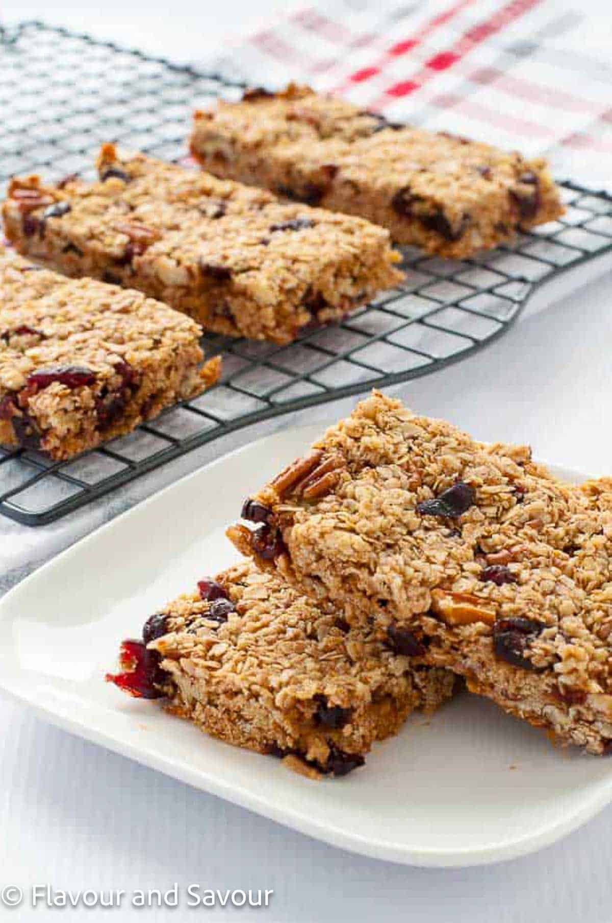 Cranberry Pecan Oat Bars on a plate and on a cooling rack.