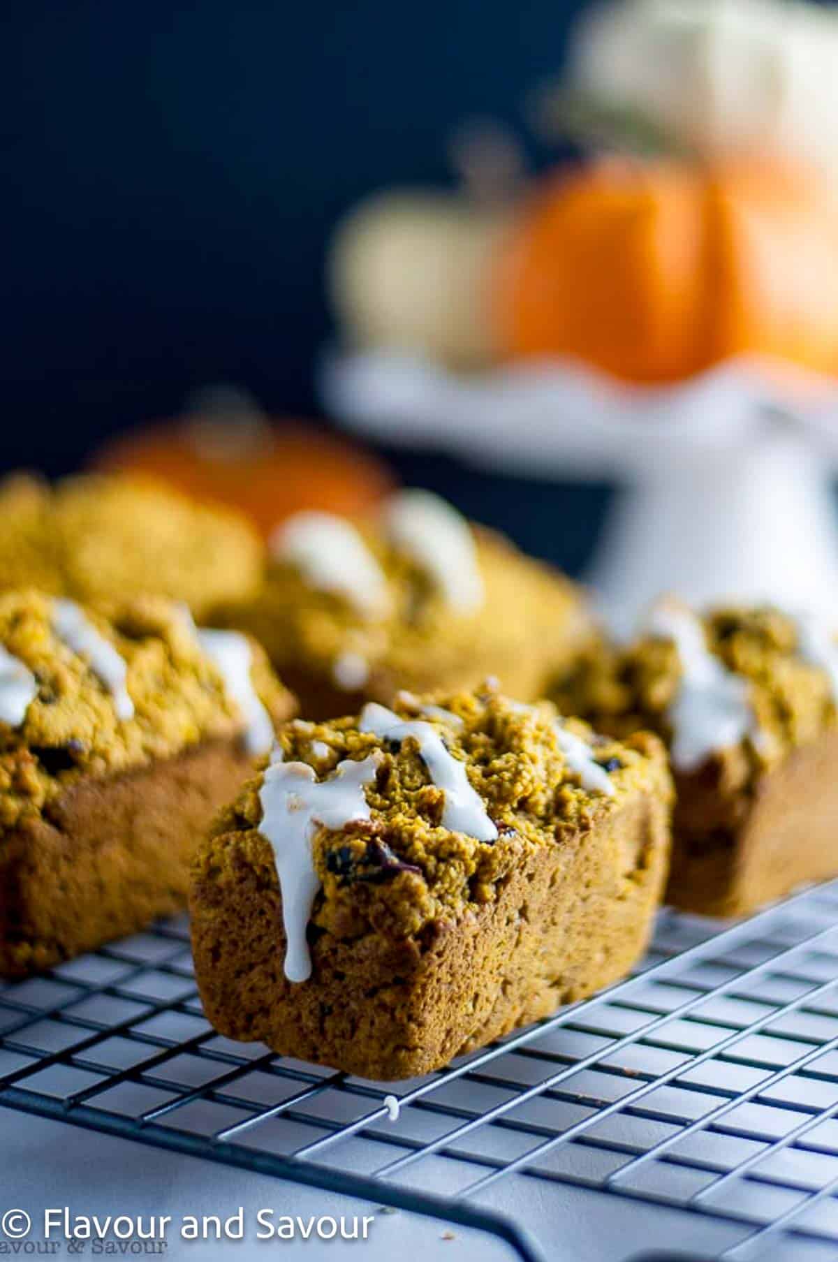 Mini gluten-free, dairy-free pumpkin loaves on a cooling rack.