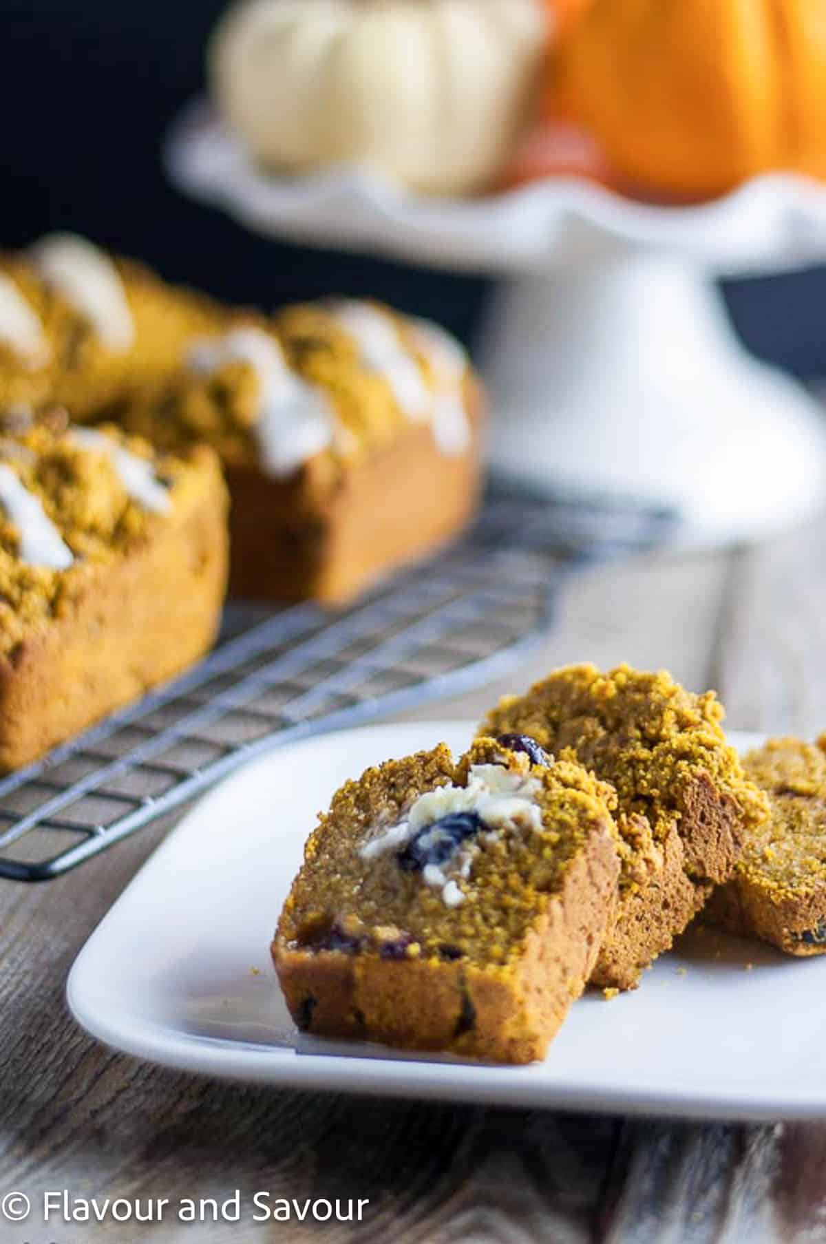 Slices of a mini gluten-free pumpkin loaf on a plate.