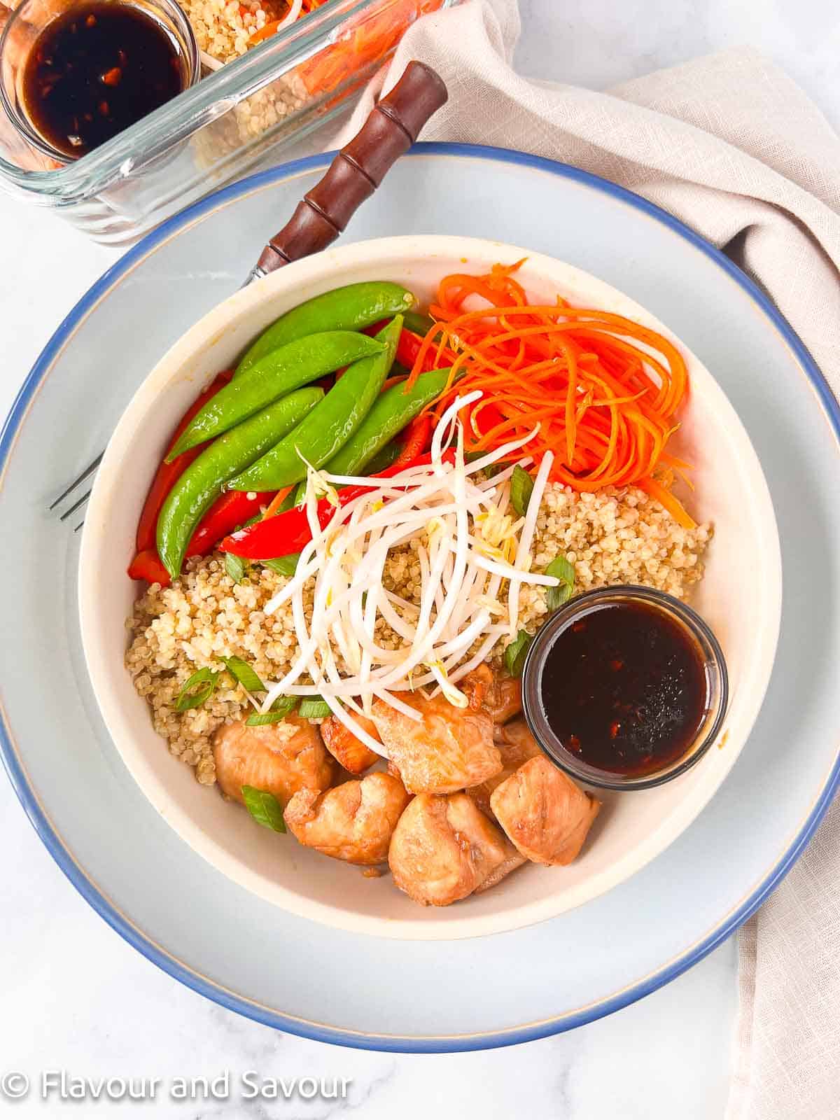 Teriyaki chicken quinoa bowl with fresh sautéed vegetables, bean sprouts and teriyaki sauce.