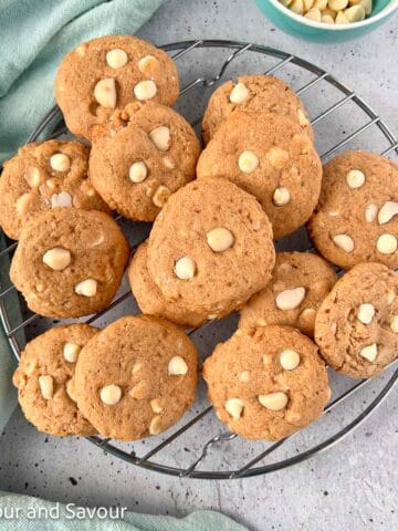 Gluten-free white chocolate macadamia nut cookies on a wire cooling rack.