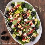 Blackberry Spinach Salad with blackberry dressing drizzled on top.