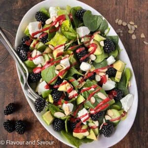 Blackberry Spinach Salad with blackberry dressing drizzled on top.