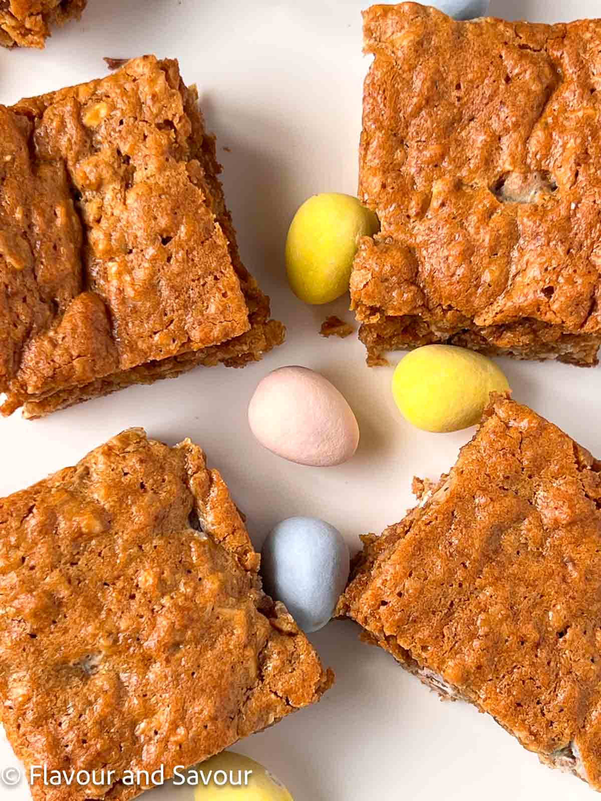 Four squares of oatmeal cookie bars on a plate.