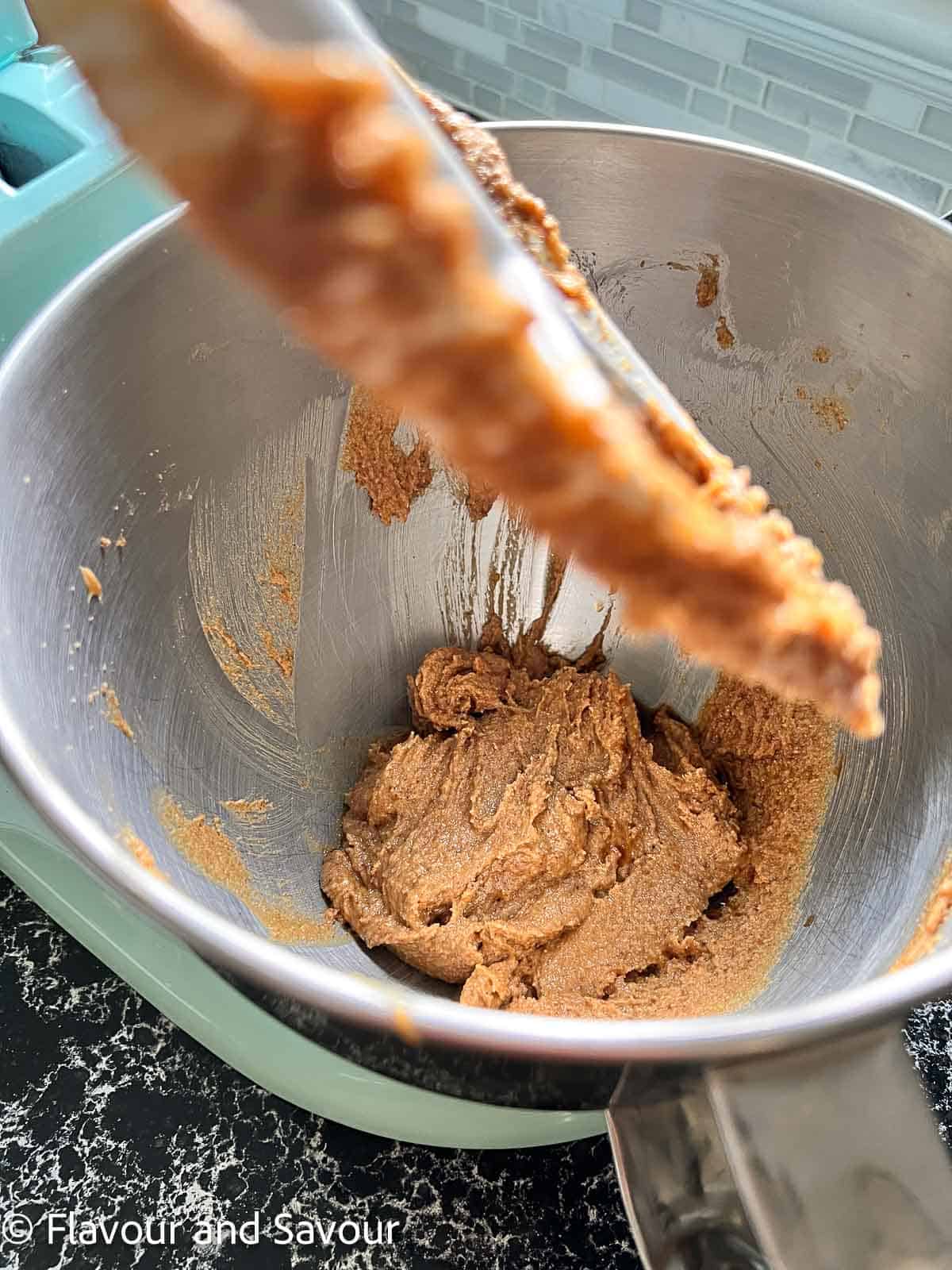 Beating butter, peanut butter, and sugar in a stand mixer.