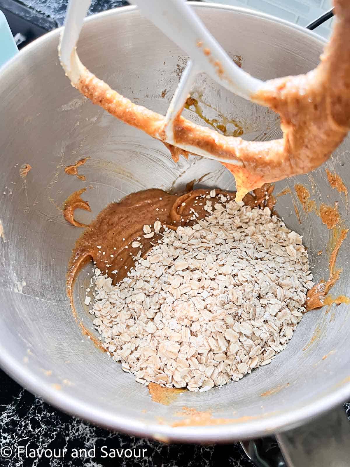 Adding oatmeal to cookie bar dough.