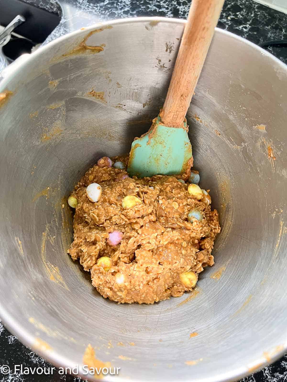 Folding in mini eggs to cookie bar dough.